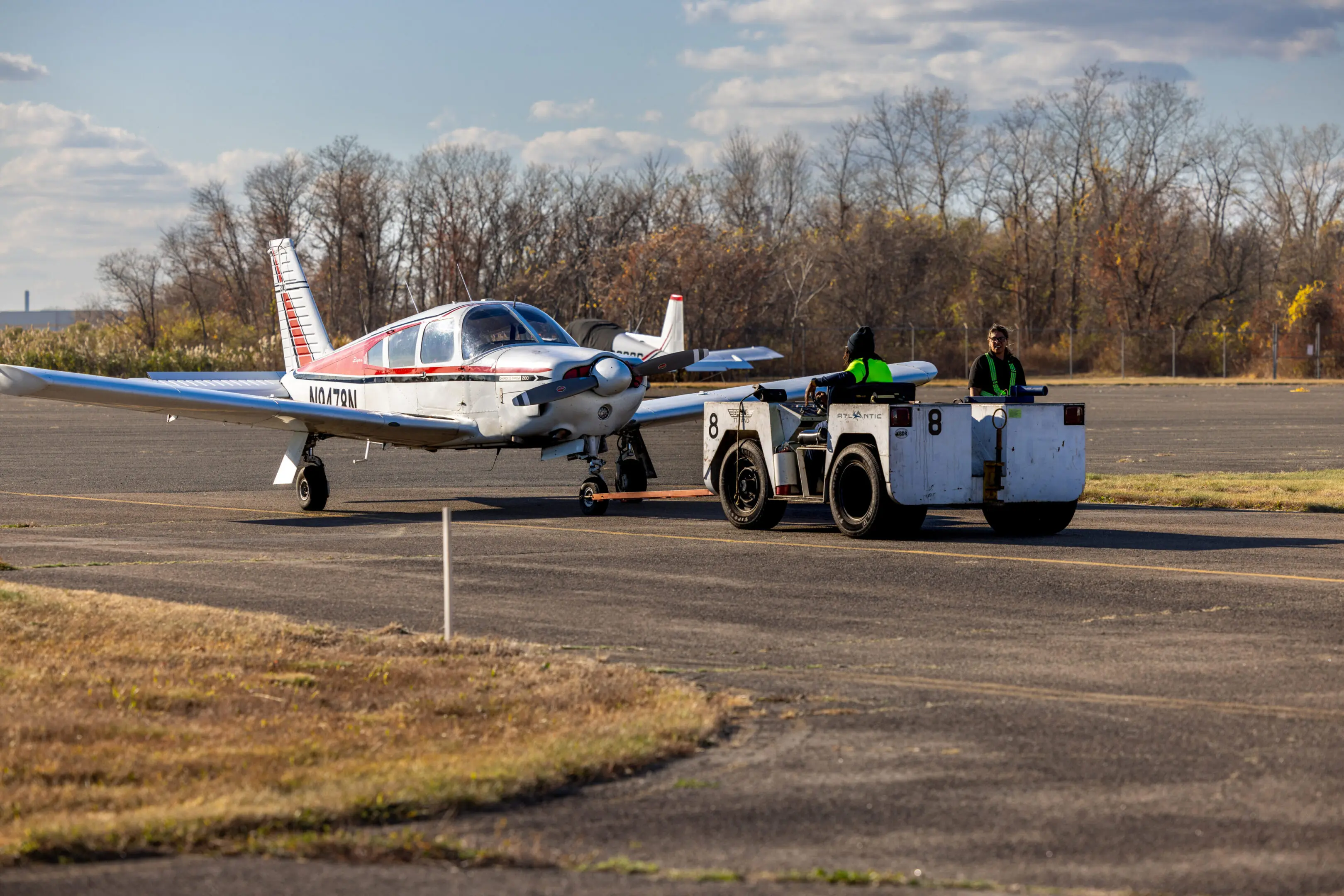 Small plane being towed on runway.