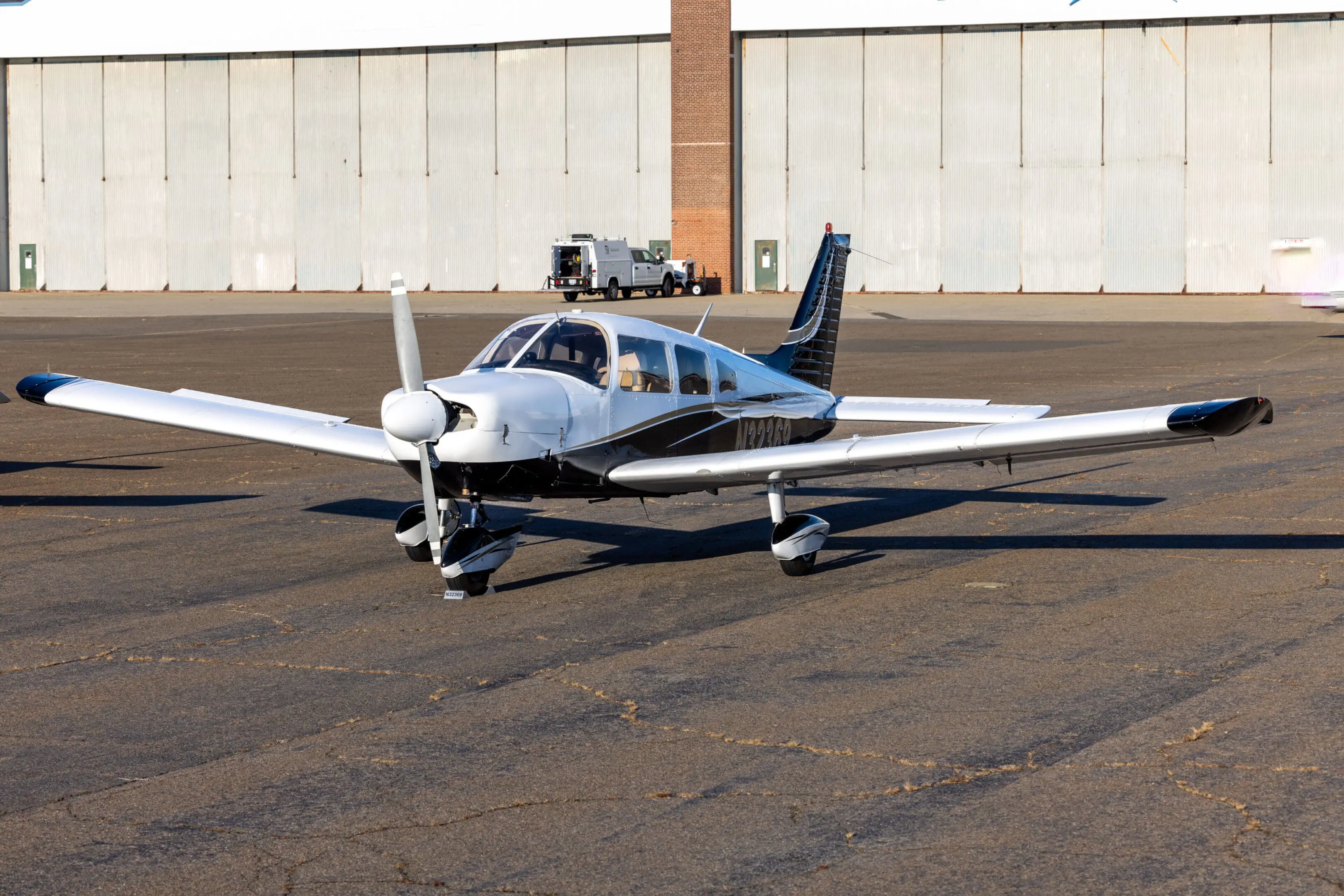 Small airplane parked on airport tarmac.
