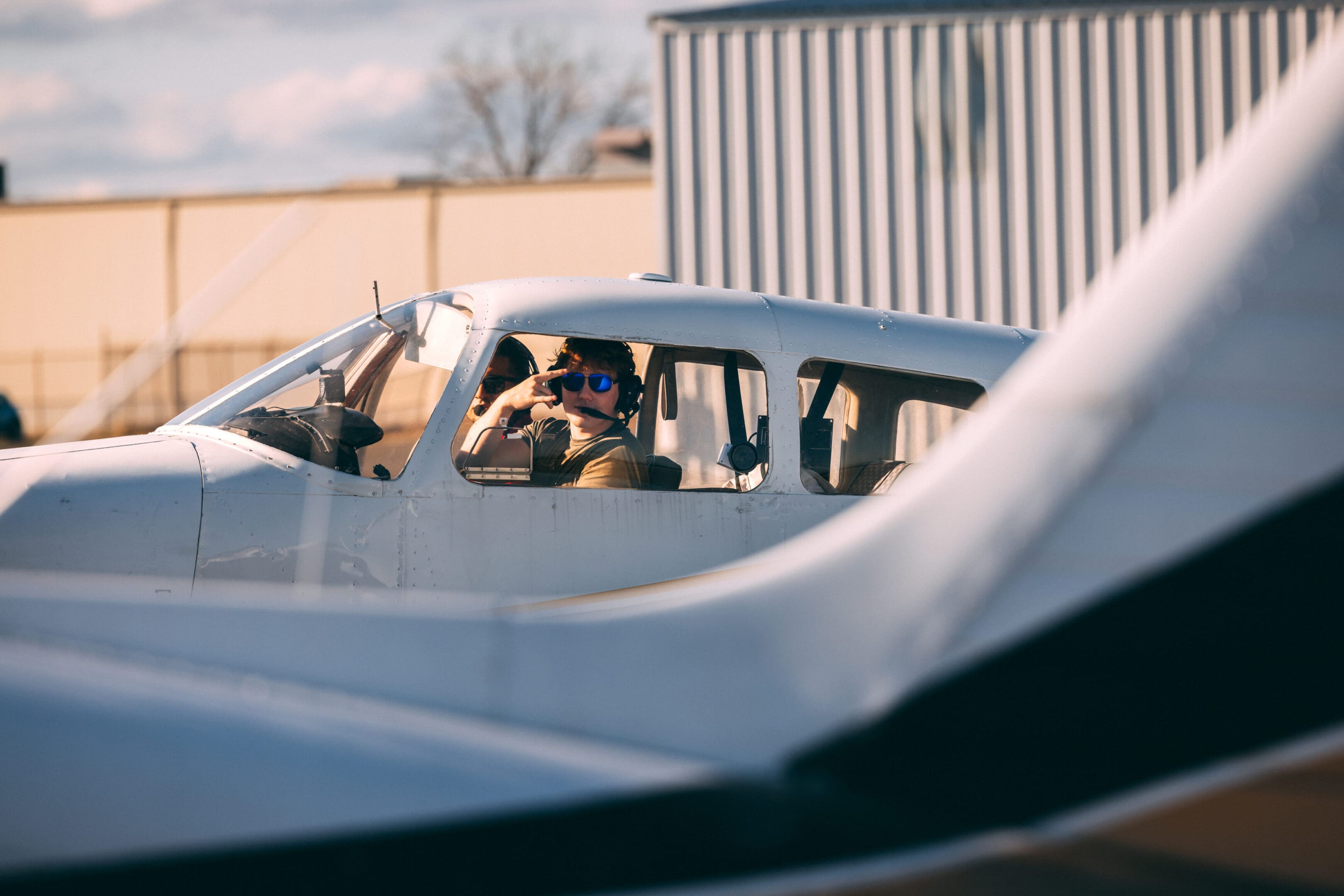 Pilot in small aircraft cockpit, headset on.