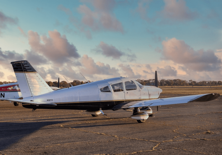 Small airplane on a tarmac at sunrise.