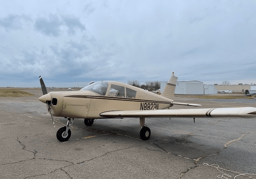 Small aircraft parked on airport tarmac.