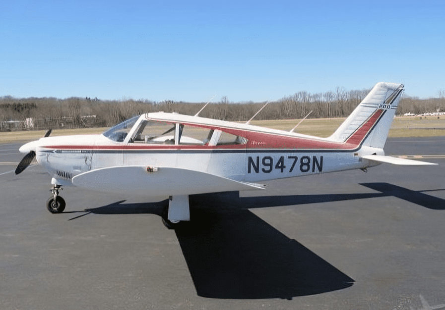 Small propeller airplane parked on tarmac.