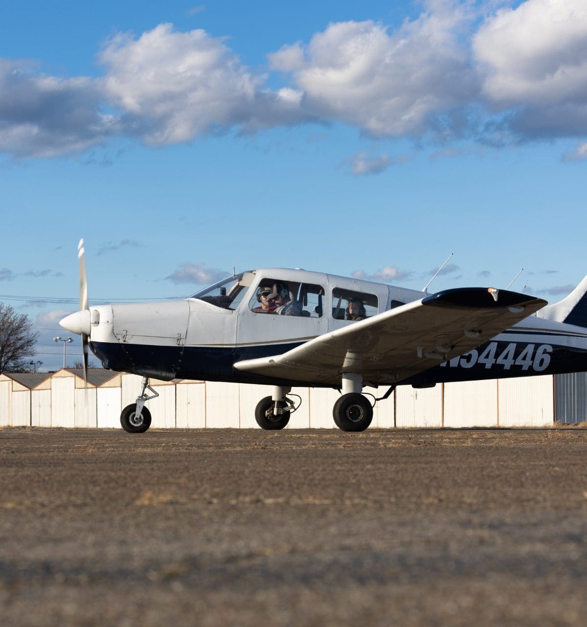 Small airplane taxiing on runway, clear sky.