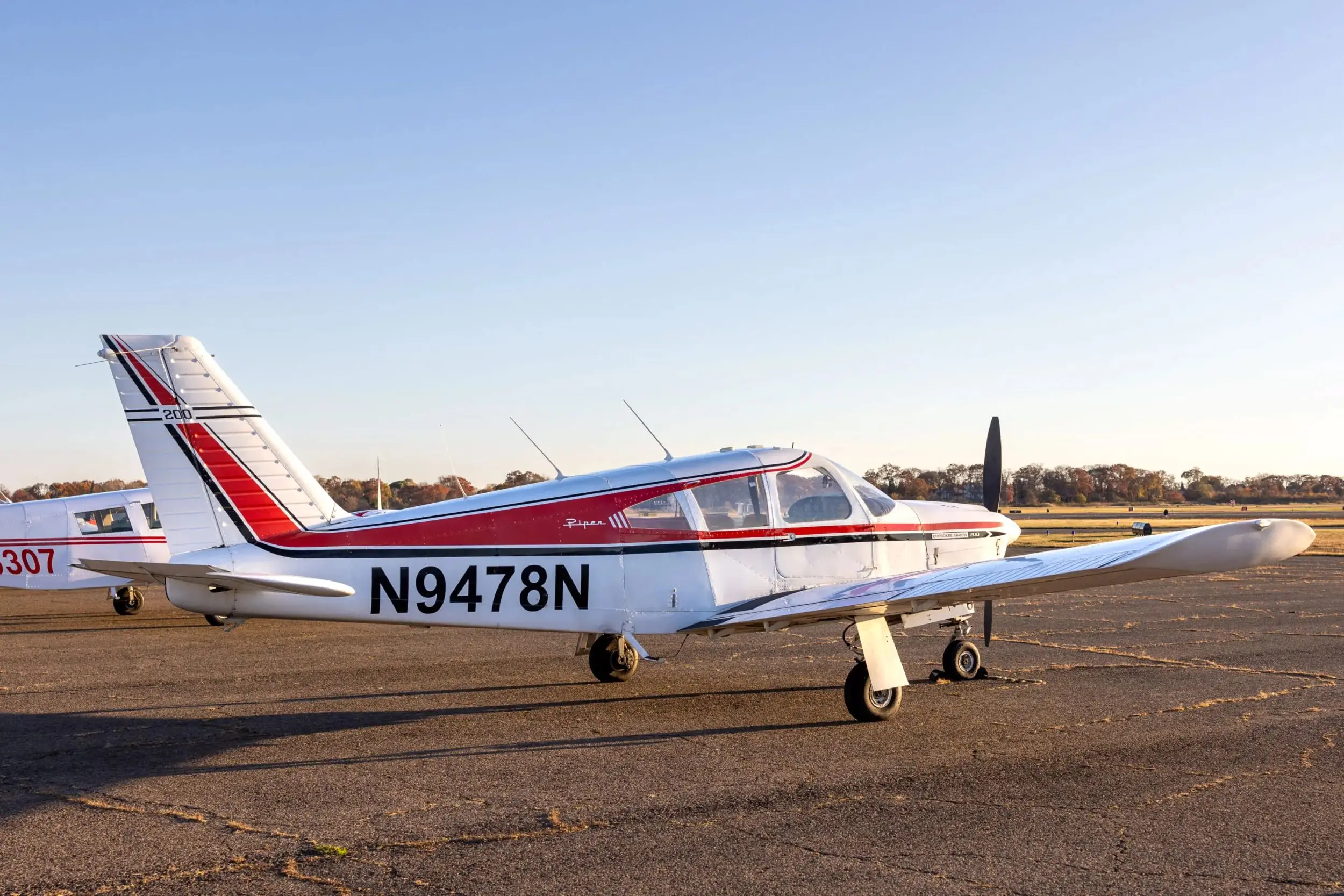 Small aircraft parked on airfield runway.