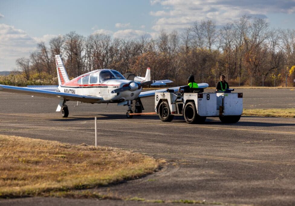 Small plane being towed on runway.