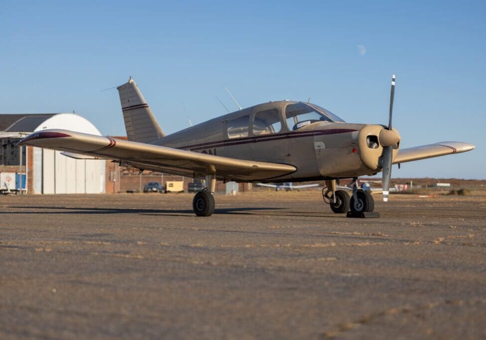 Small airplane parked on airport tarmac.